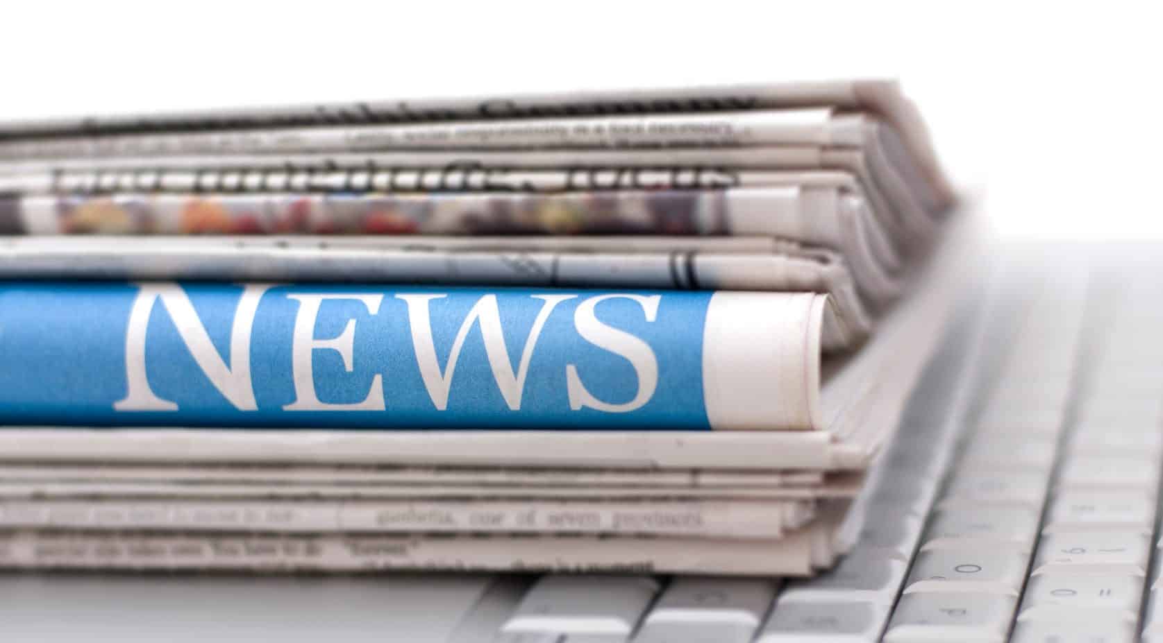 a stack of newspapers on a keyboard